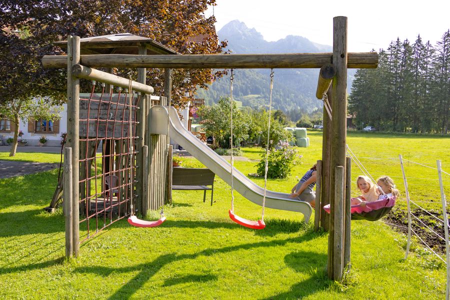 Spielturm mit Rutsche im Garten des Hofs