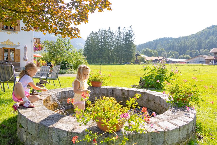 Kinder am runden Brunnen im Garten